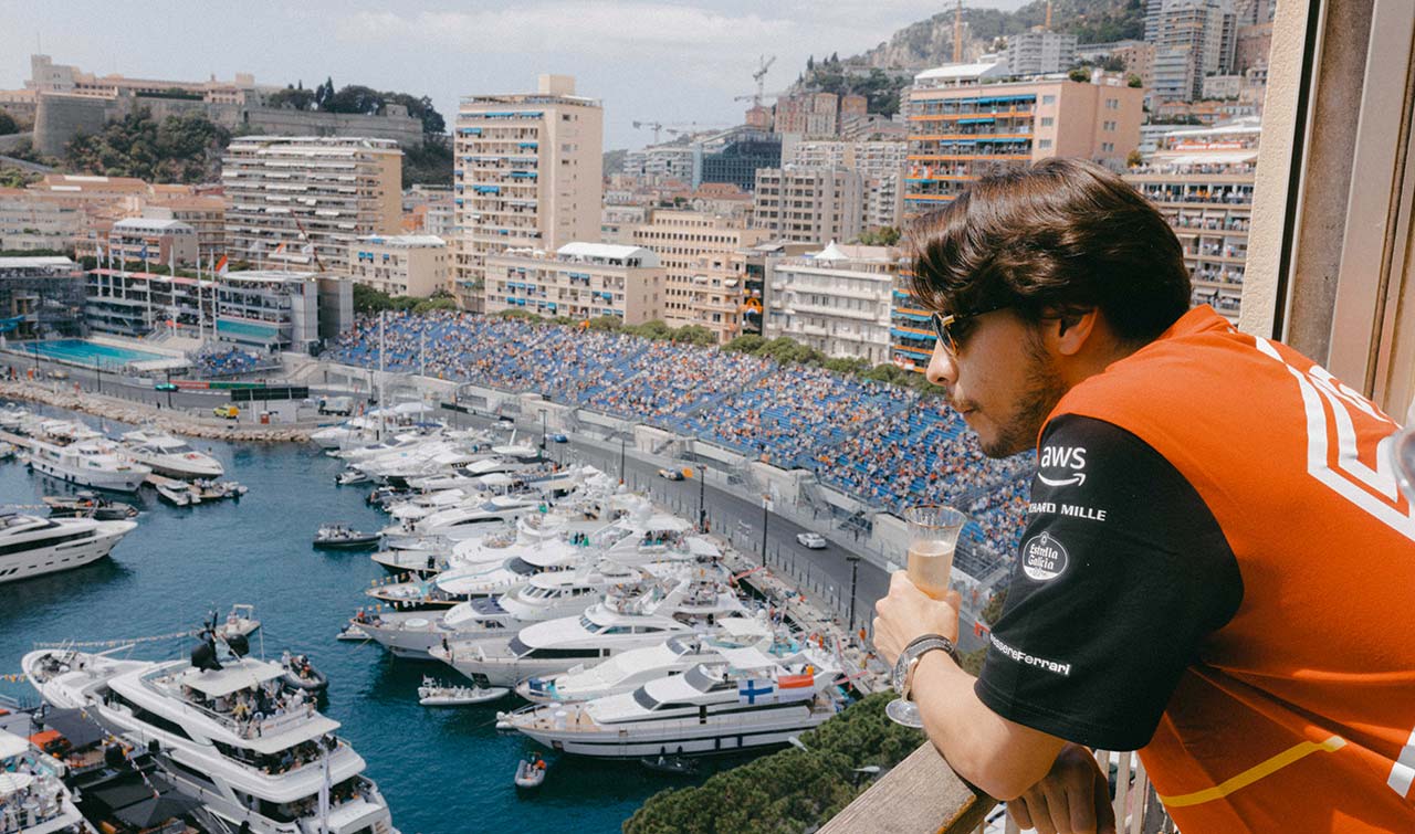 f1 spectator looking on to the monaco harbour from a balcony with view of all the yachts and grandstands