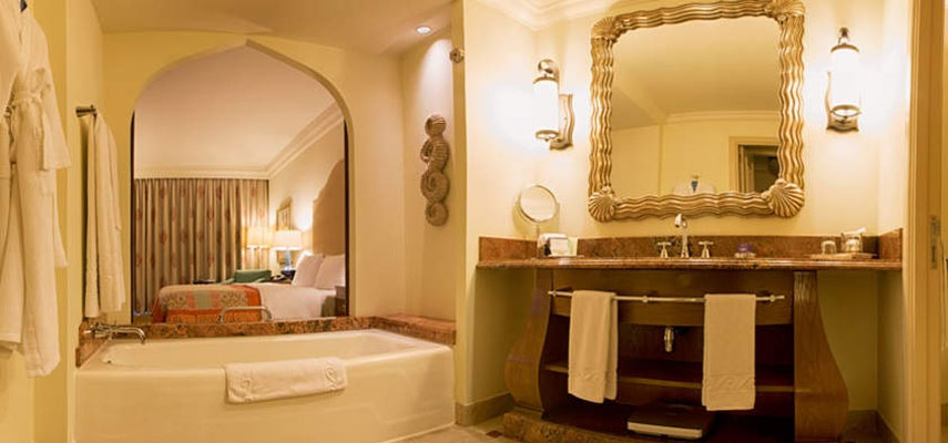 hotel bathroom with large mirror, sink and bath in view