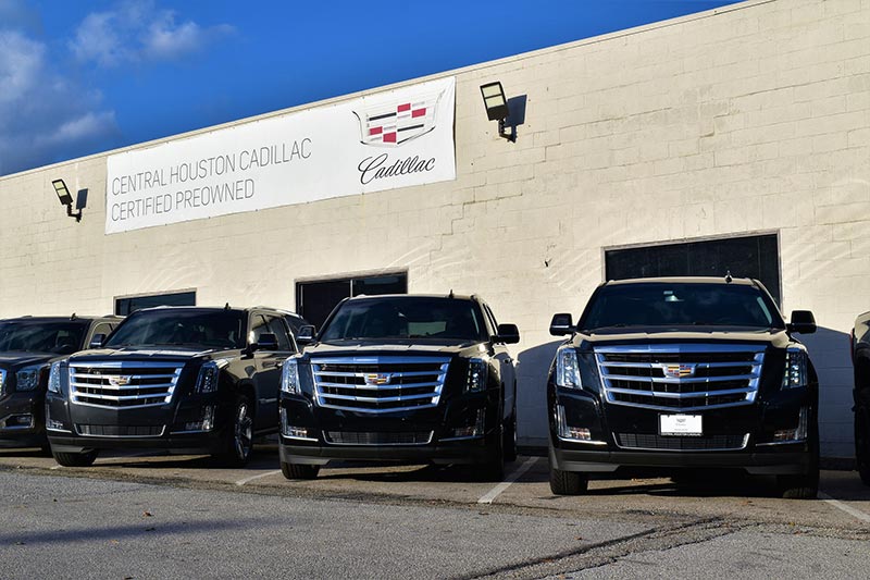 3 cadillacs lined up in a row with a message above them
