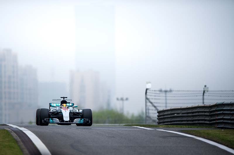 mercedes f1 car racing in china, dark overcast sky above