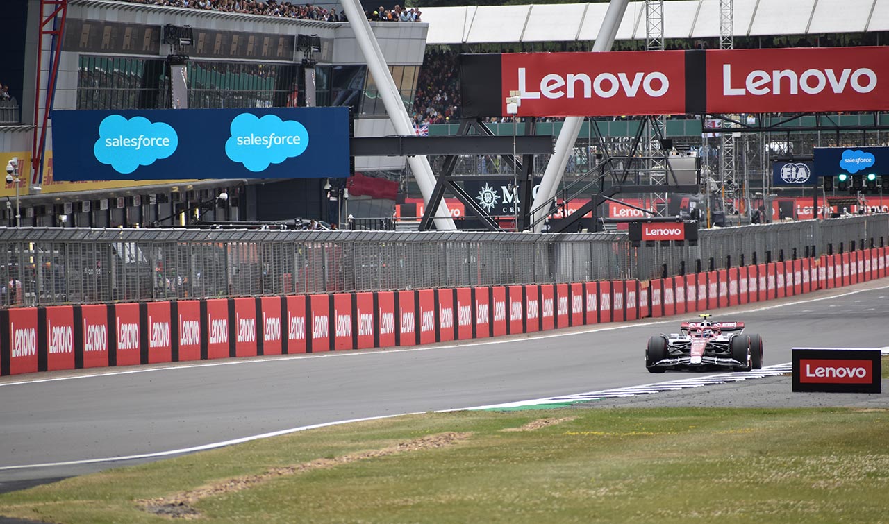 f1 car racing with lenovo and sales force signs all around