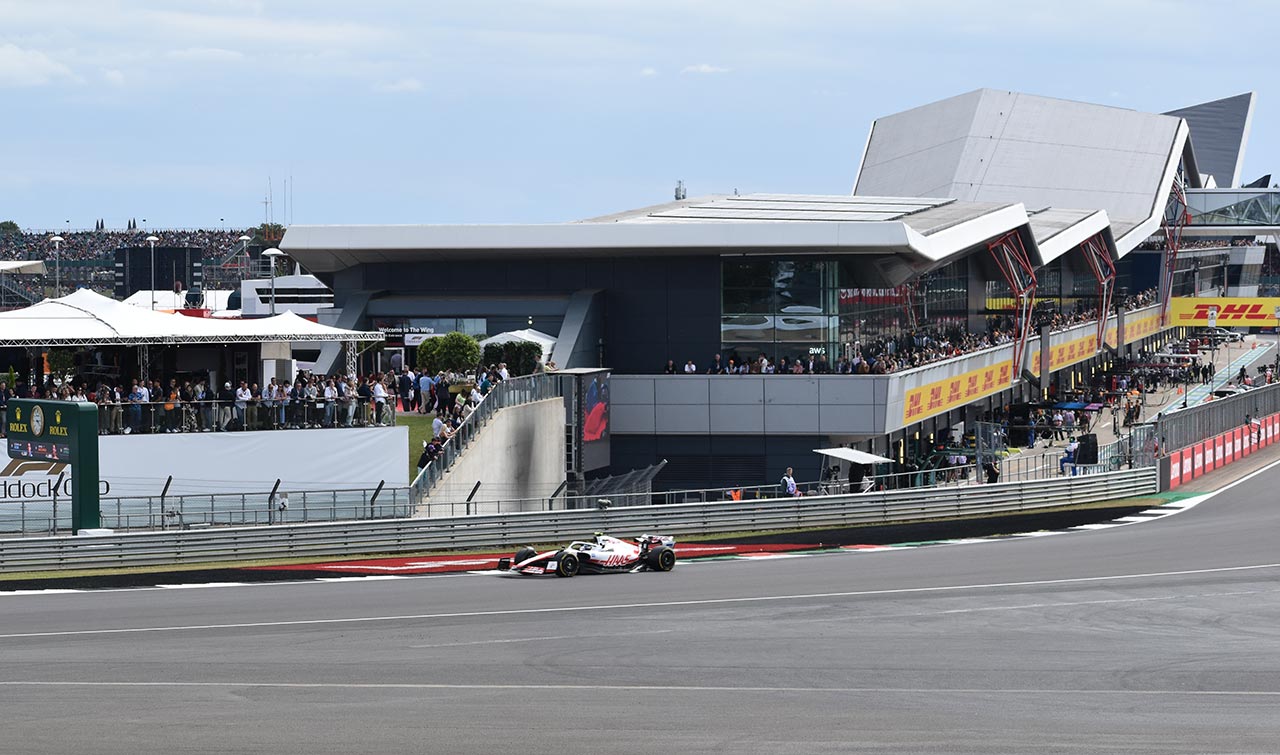haas team f1 car passing the paddock viewing area