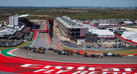 formula one cars in action racing around a corner in austin