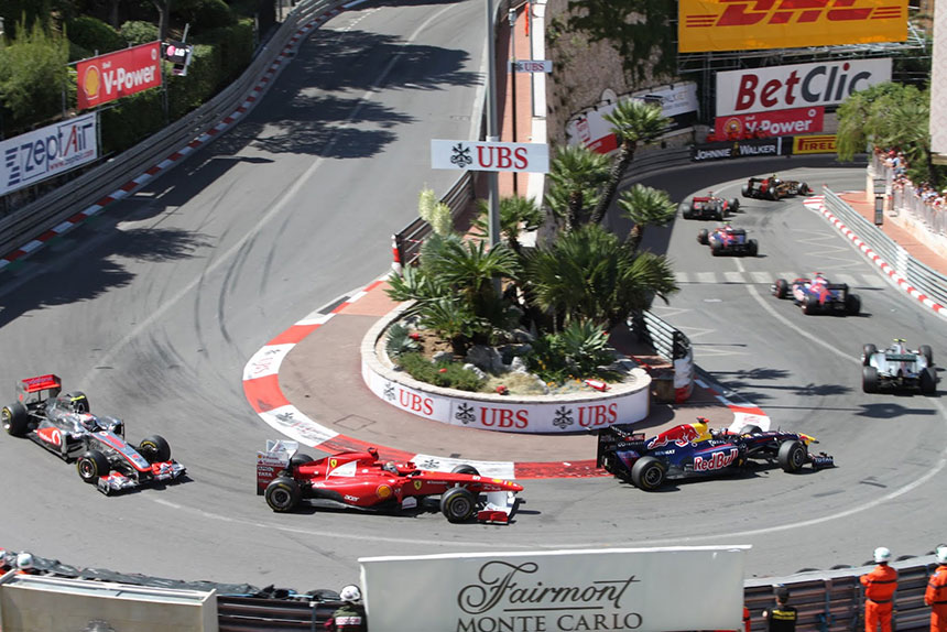 f1 cars racing round a corner in monaco