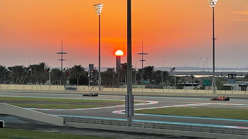 sunset over the track with 2 racing cars in the distance