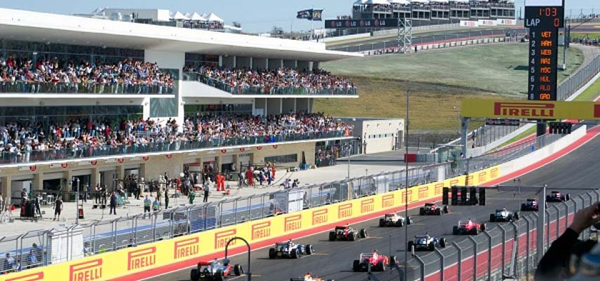 f1 cars ready to race and a crowd of spectators