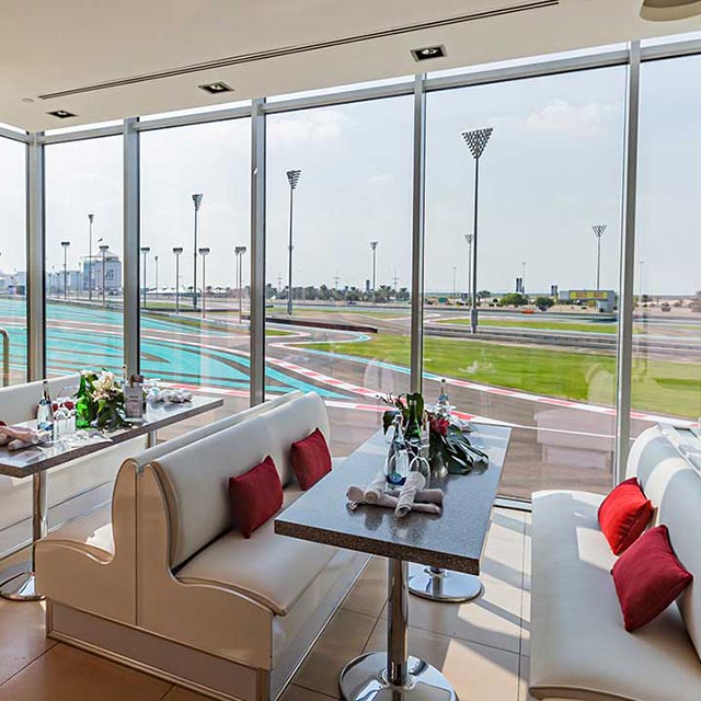 empty lounge with red cushions and couches looking onto the abu dhabi race track