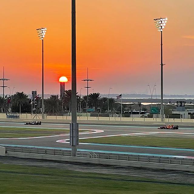2 f1 cars racing at sunset in abh dhabi