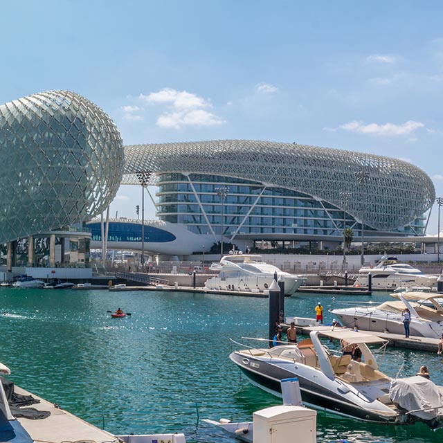 harbour in abu dhabi with boats and glass building in the background