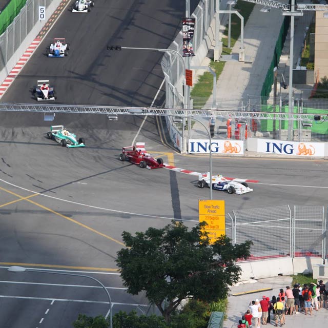 f1 cars racing around a corner