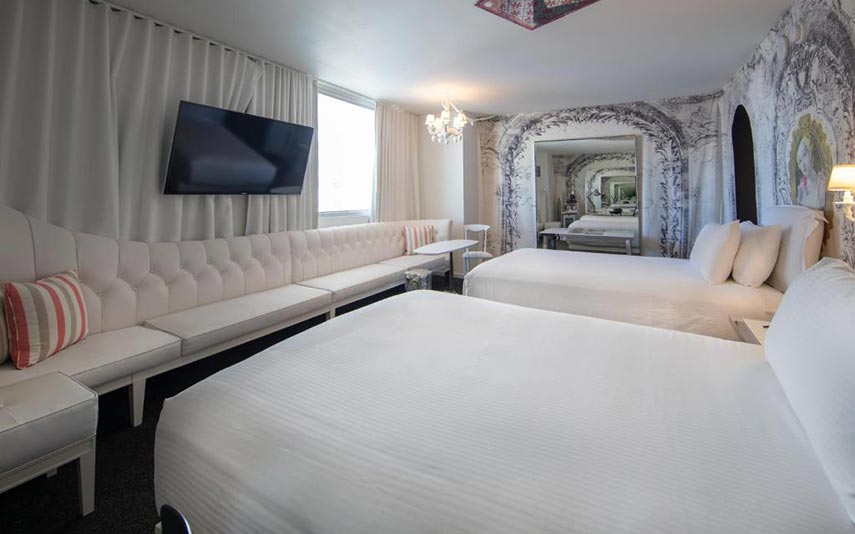 twin rood with large double beds and a couch, TV and large mirror