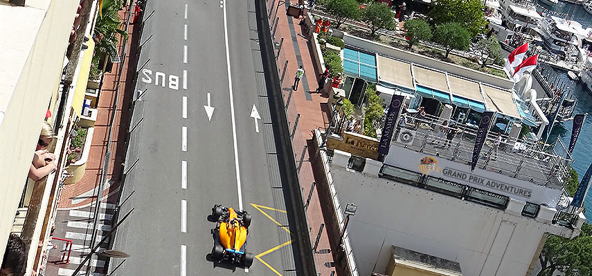 looking down on a yellow f1 car from a balcony