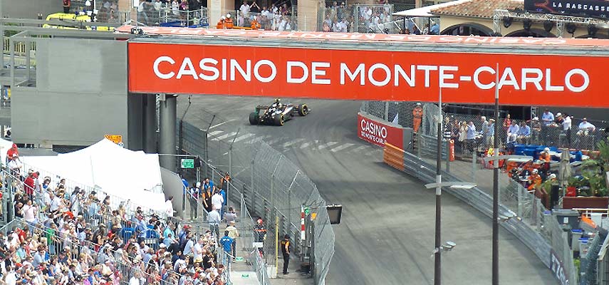F1 car racing past a large sign saying casino de monte-carlo