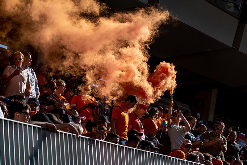 spectators at the austrian grand prix with orange smoke flares