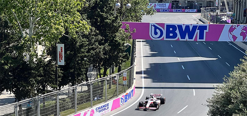 f1 car racing in baku with a BWT sign