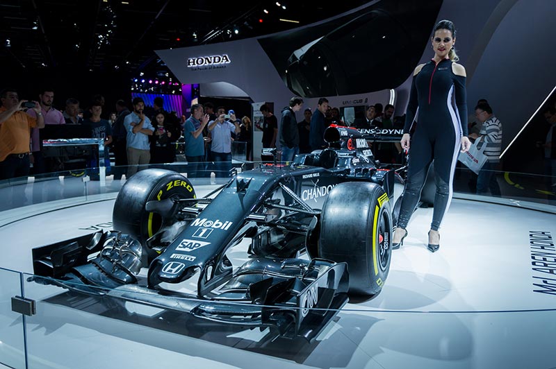f1 car with woman driver standing beside it in a TV studio