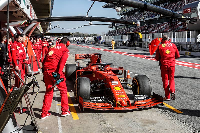 ferrari team with racing car in the pits
