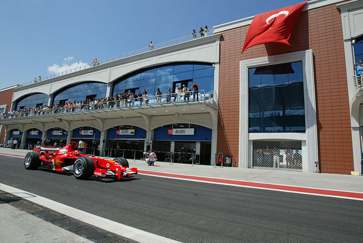 ferrari f1 car racing past a stadium in turkey
