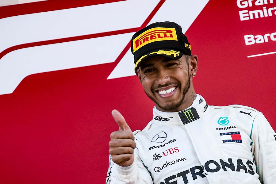 lewis hamilton f1 driver showing the thumbs up and looking happy