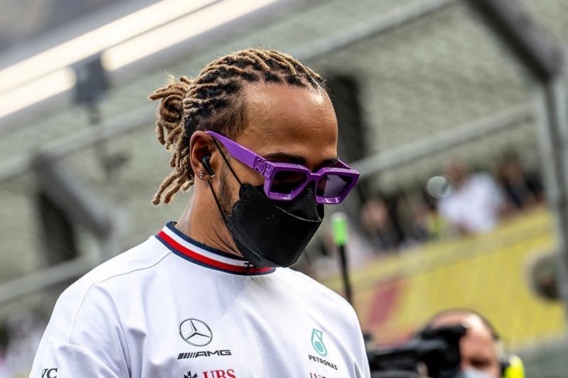 lewis hamilton with a face mask on and colourful glasses