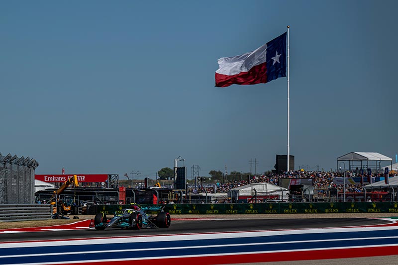 mercedes f1 car racing in austin with texas flag in background
