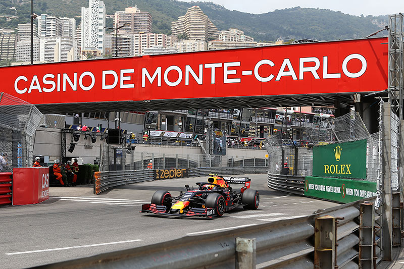 the famous casino de monte carlo sign with a f1 car racing underneath