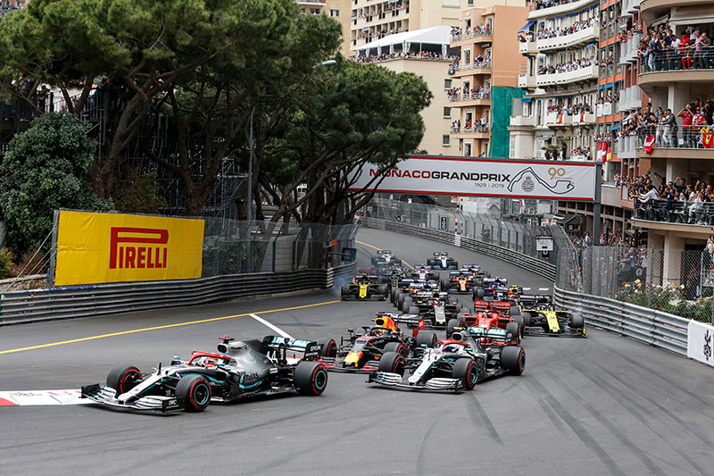 f1 racing cars at the first turn in monaco