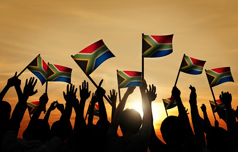 crowd of people holding up south african flags