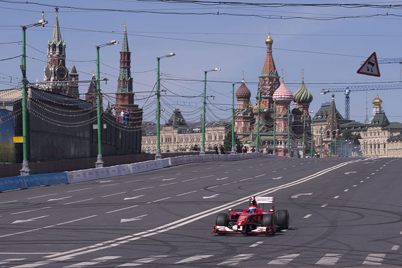 f1 racing cars with historic buildings in the backround