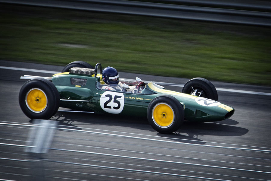 green vintage f1 car racing in the grand prix with the number 25