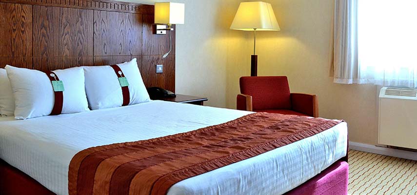 double bed in hotel with chair and lamp