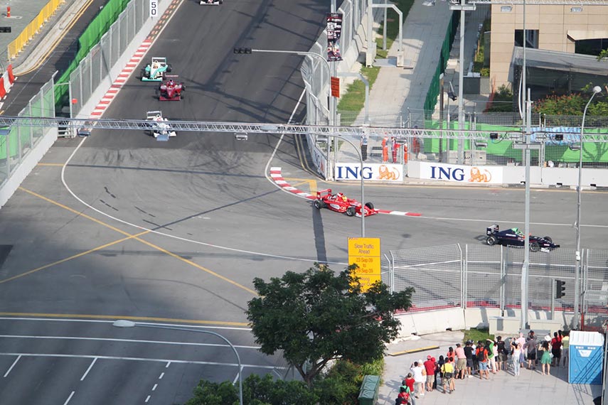 racing cars speeding past a view from the balcony