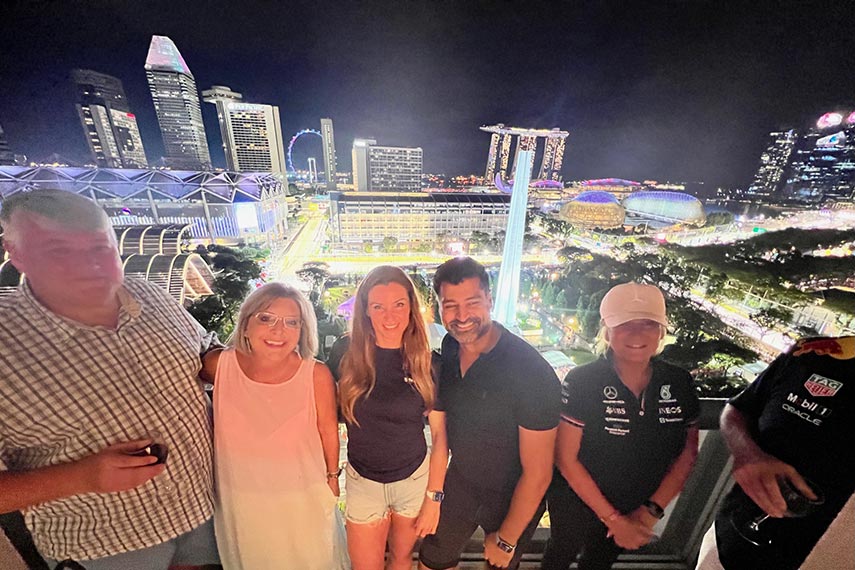 happy guests smiling with singapore at night in the distance