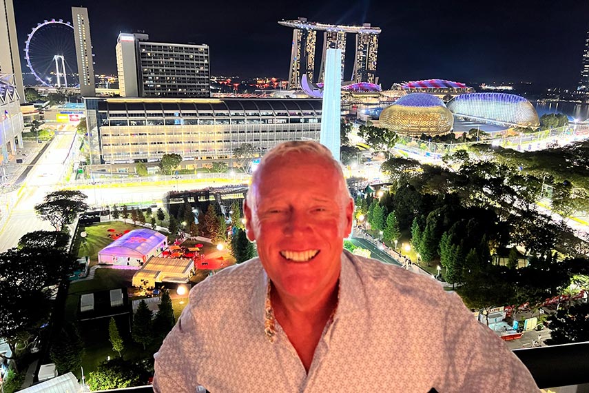 man smiling with singapore to the back of him