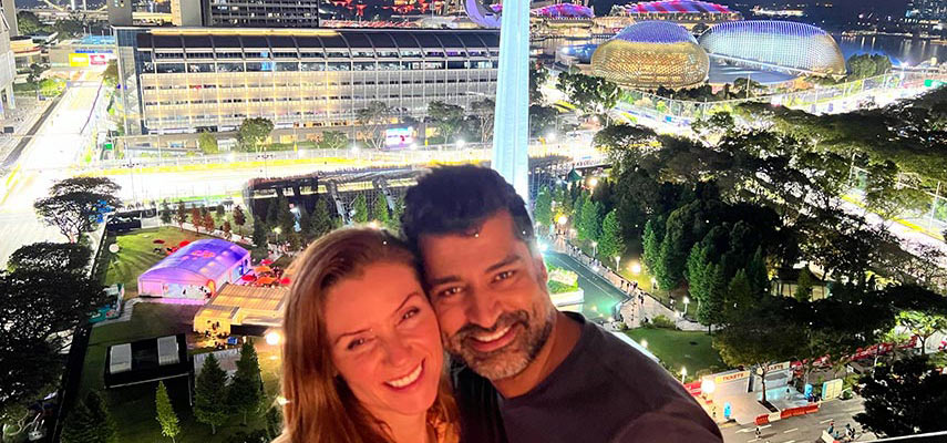 couple of guests smiling overlooking singapore at night