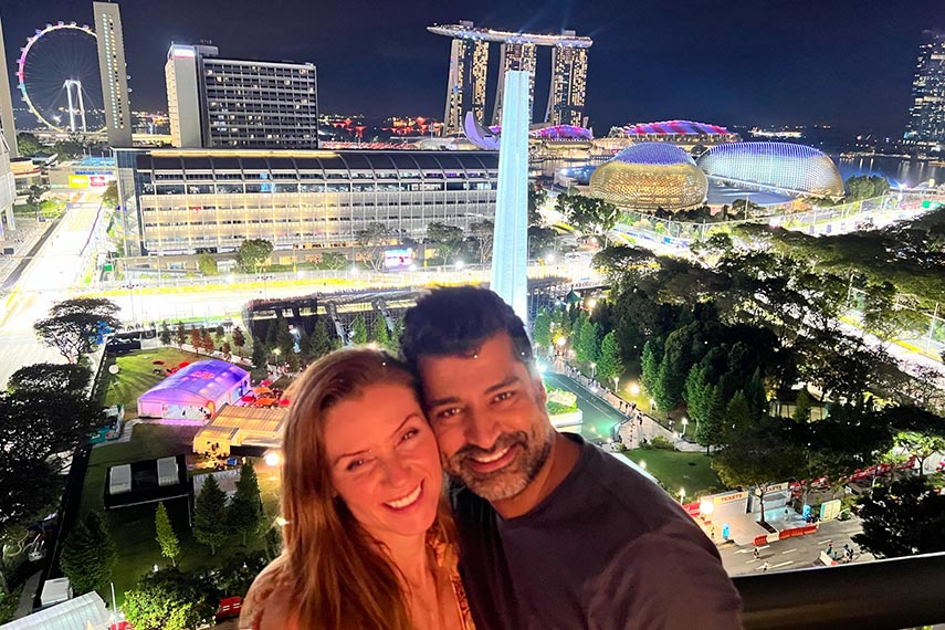 couple of guests smiling overlooking singapore at night