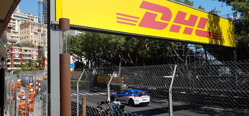 sports car racing past with a DHL sign in view