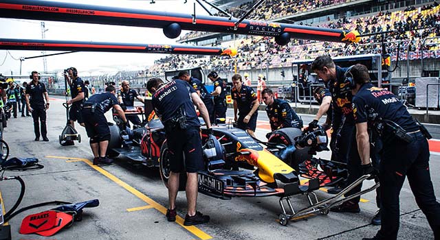 Red Bull F1 team working on a Formula One car in the pits at the grand prix